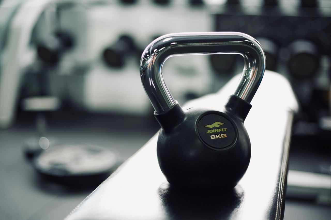 Home Black kettlebell on gym bench highlighting fitness and strength training equipment.